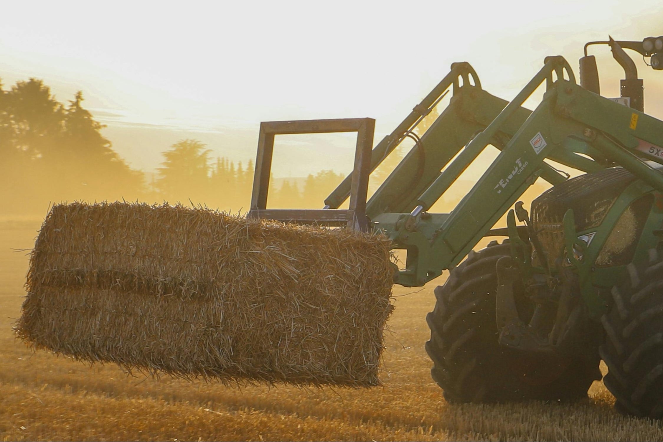 Tractor working in a field with fork attachment